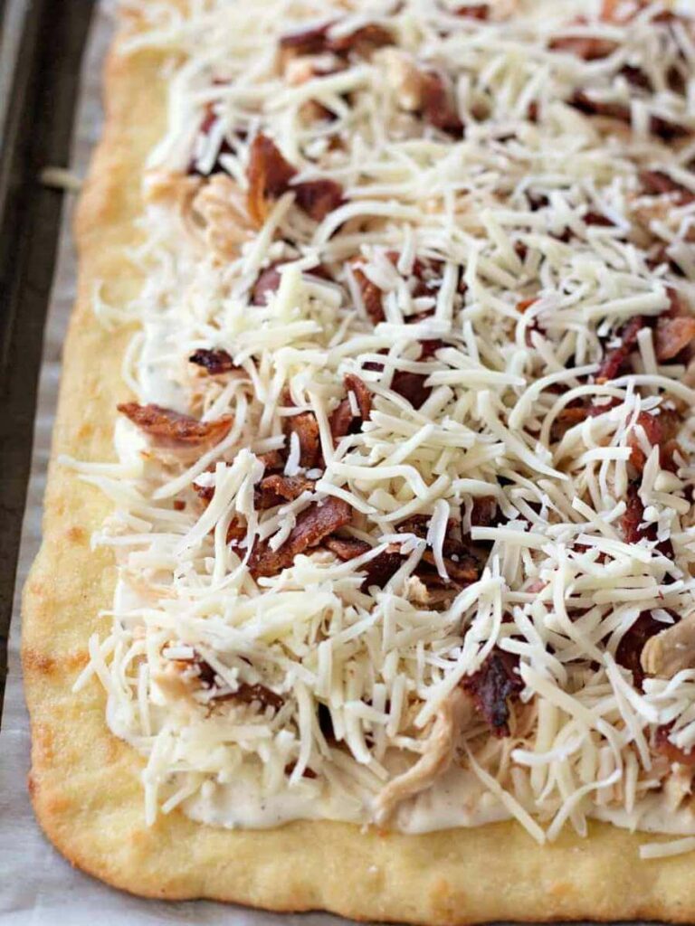 Adding toppings to a keto pizza Adding toppings to a keto pizza