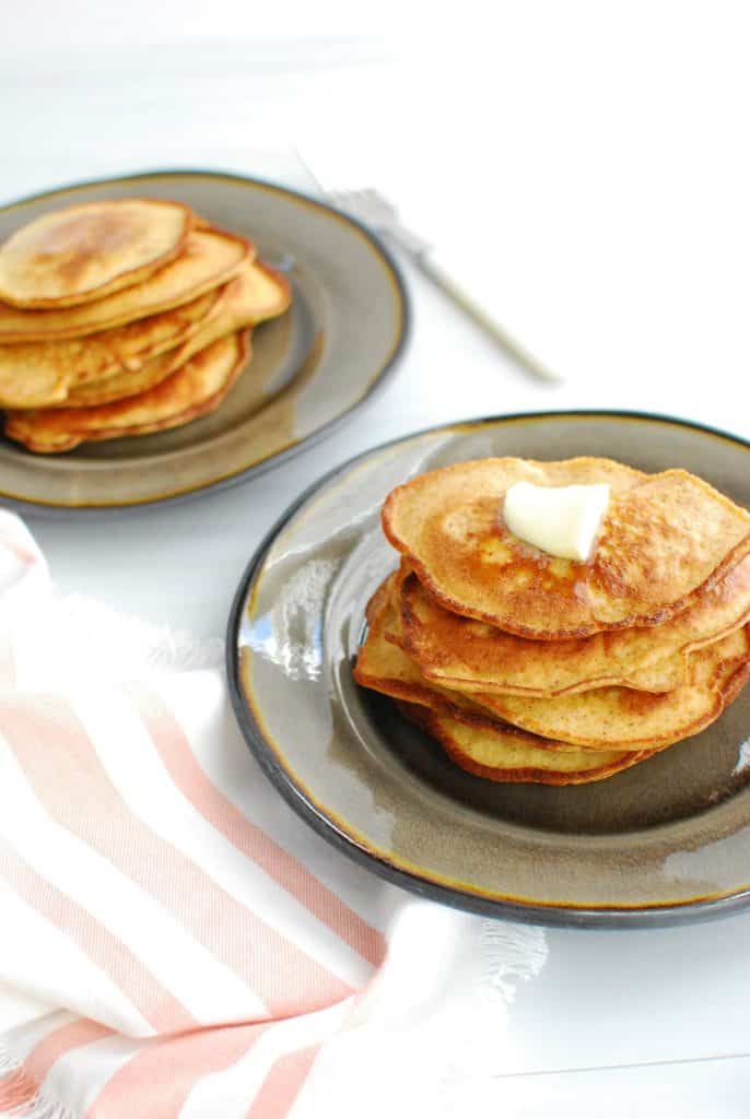 Two plates full of low carb pancakes topped with butter Two plates full of low carb pancakes topped with butter