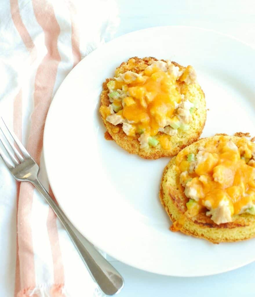 an open faced keto tuna melt on a white plate next to a fork an open faced keto tuna melt on a white plate next to a fork
