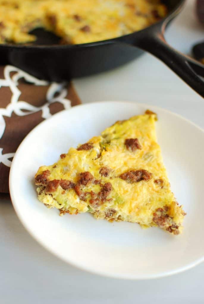 A close up of a slice of keto frittata on a white plate A close up of a slice of keto frittata on a white plate
