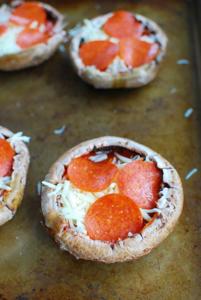 Keto stuffed portabello mushroom pizzas on a baking sheet Keto stuffed portabello mushroom pizzas on a baking sheet
