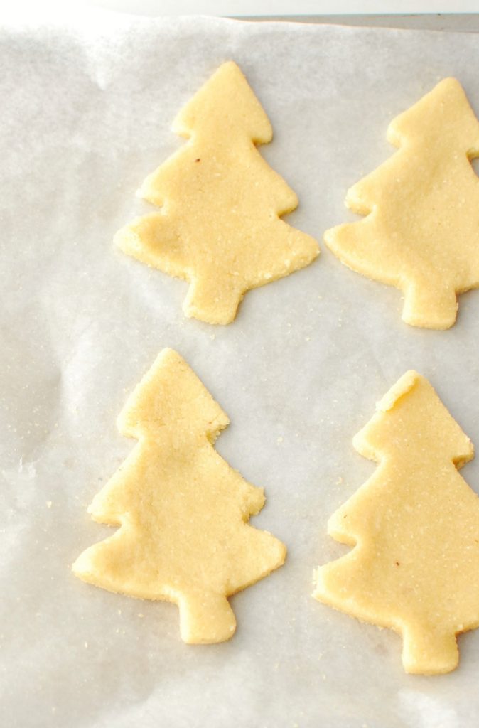 keto christmas cookies shaped like trees on a baking sheet before baking keto christmas cookies shaped like trees on a baking sheet before baking