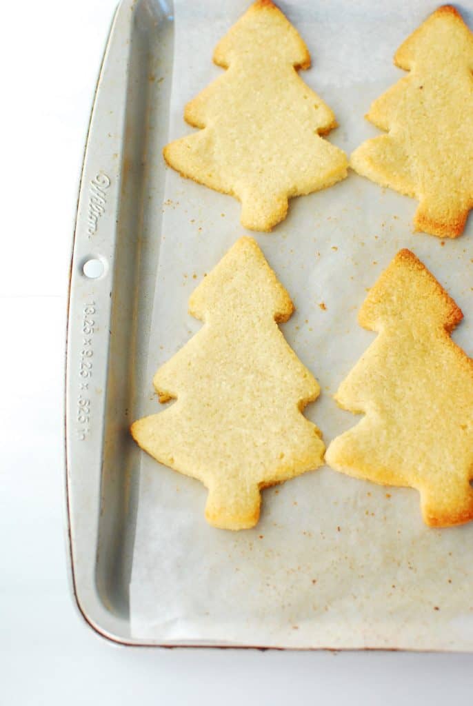 keto christmas cookies shaped like trees on a baking sheet after baking keto christmas cookies shaped like trees on a baking sheet after baking