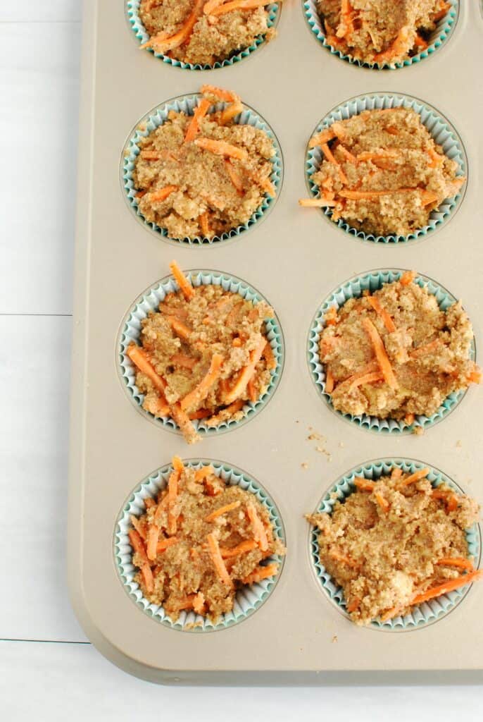 Muffin batter filling up the cups of a muffin tin. Muffin batter filling up the cups of a muffin tin.