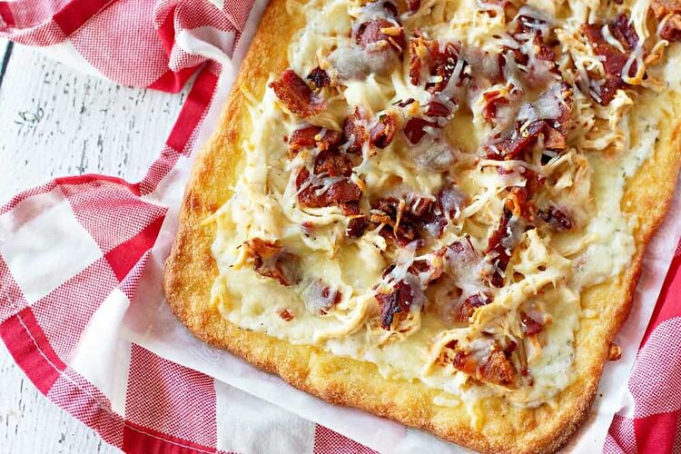 Keto pizza topped with ranch, bacon, chicken, and mozzarella