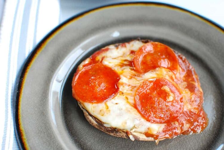 A portaebello mushroom stuffed with pizza ingredients
