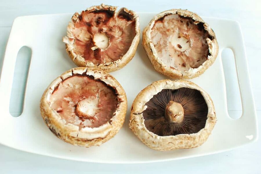 four portabello mushrooms - three with stems and gills removed and one still intact four portabello mushrooms - three with stems and gills removed and one still intact