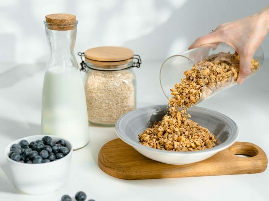 Our Low-Carb Keto Granola Recipe pouring into a bowl - Yummy Keto Cooking Our Low-Carb Keto Granola Recipe pouring into a bowl - Yummy Keto Cooking