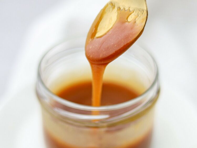 Keto Caramel Sauce Recipe Being Poured into a Jar - Yummy Keto Cooking