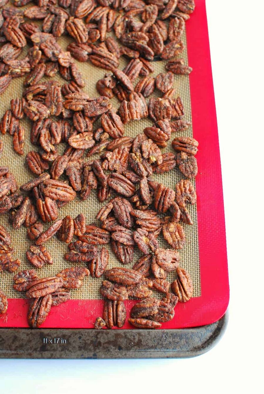Low carb candied pecans on a baking sheet after coming out of the oven Low carb candied pecans on a baking sheet after coming out of the oven