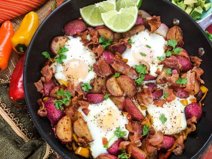 a large skillet filled with radishes, peppers, onions, and eggs a large skillet filled with radishes, peppers, onions, and eggs