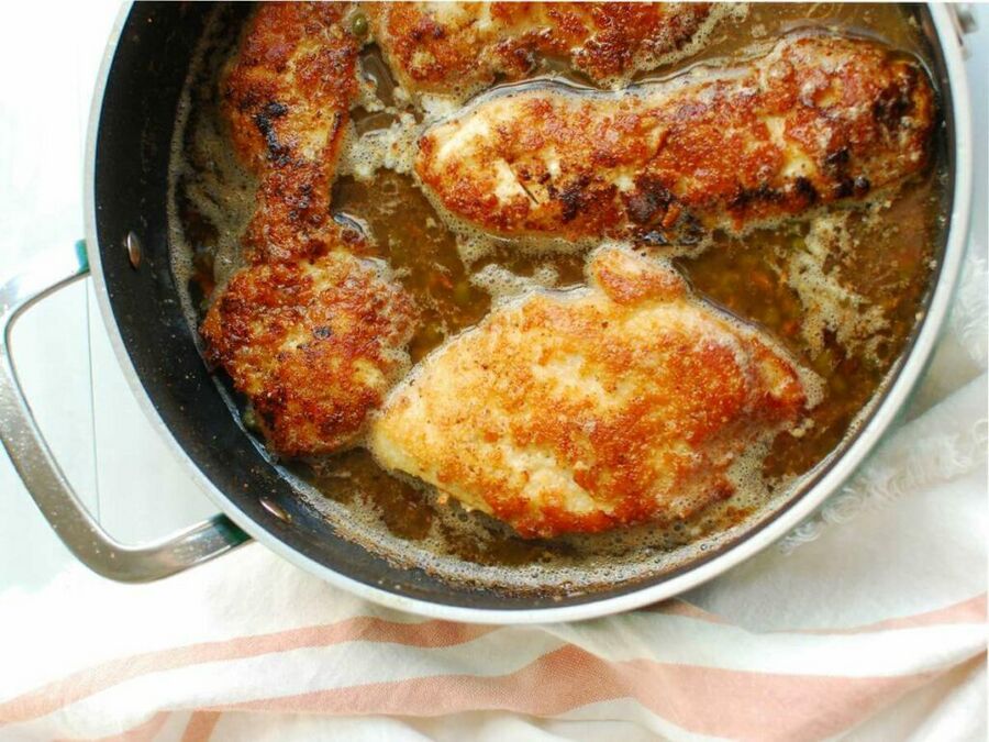 A pan with chicken cutlets and lemon butter sauce A pan with chicken cutlets and lemon butter sauce