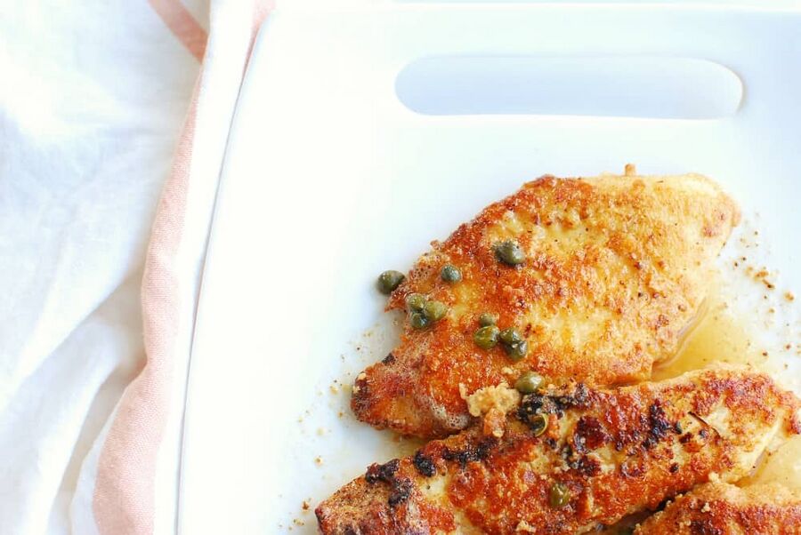 low carb chicken piccata on a white plate next to a napkin low carb chicken piccata on a white plate next to a napkin