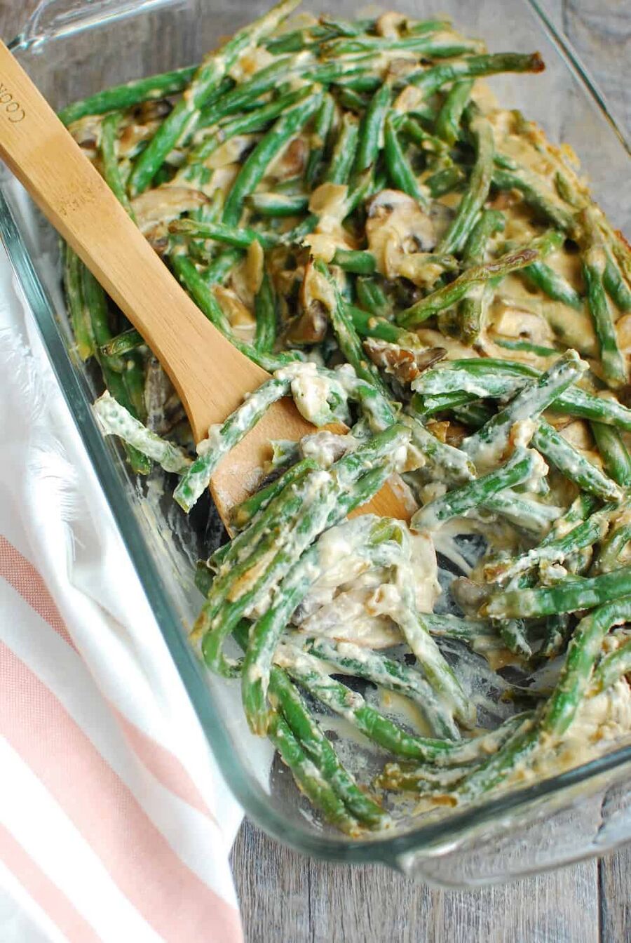 A wooden spoon in a casserole dish full of low carb green bean casserole A wooden spoon in a casserole dish full of low carb green bean casserole