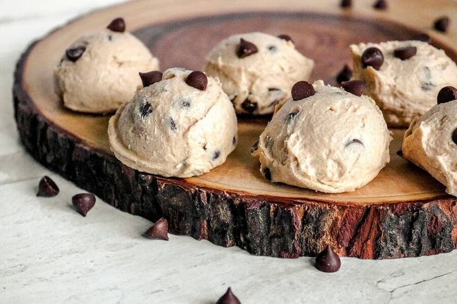 several balls of keto cookie dough on a wooden serving block several balls of keto cookie dough on a wooden serving block