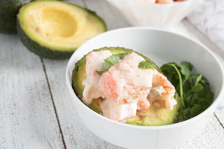 keto crab meat salad stuffed avocado in a white bowl
