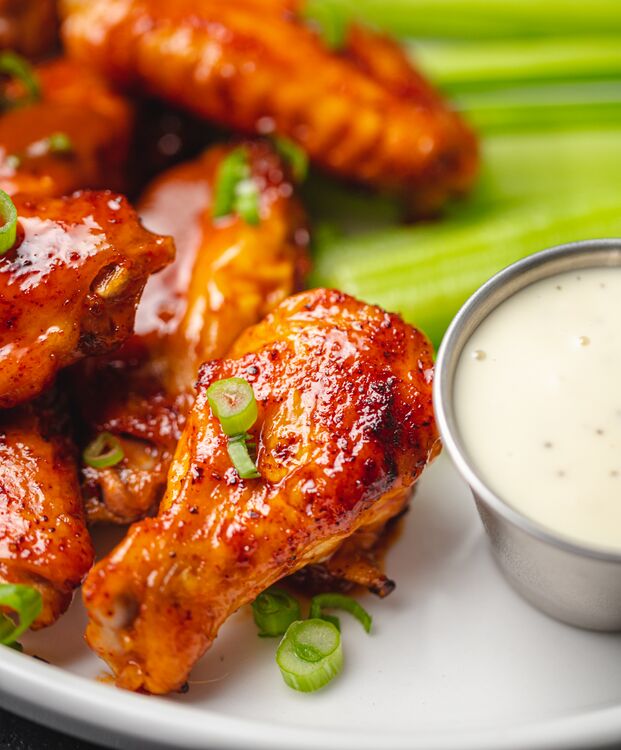 Delicious keto buffalo wild wings on a plate with some dip - Yummy Keto Cooking